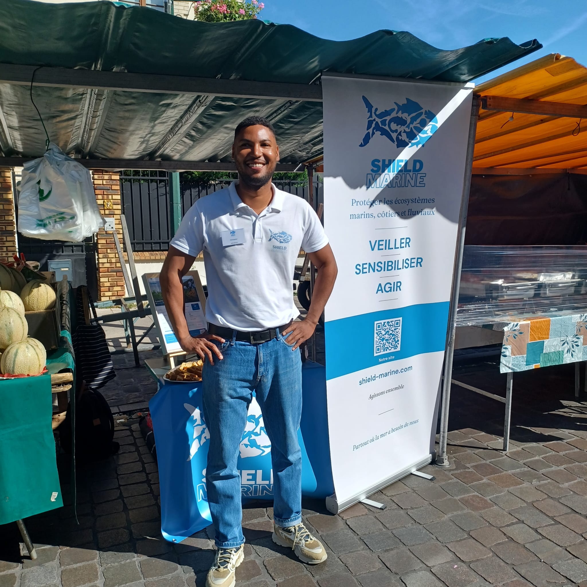 Bénévole Shield Marine devant le kakémono au marché Dampierre Bagneux juin 2026